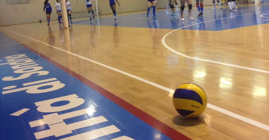 pallone in primo piano con squadra sullo sfondo